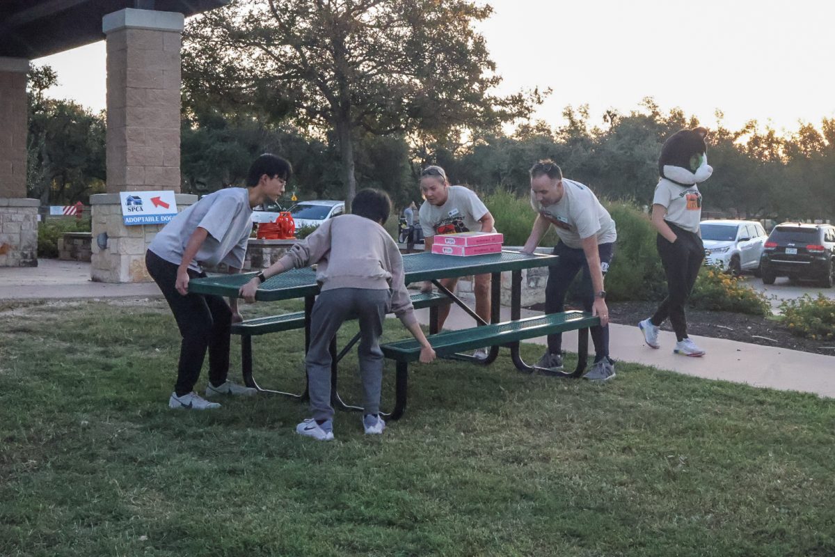 Clocking in at 7 a.m., Benjamin Li '25 and Andrew Zhang '25 work with the Central Texas SPCA staff to arrange tables for booths at the event. Barktoberfest had various booths such as ones for small businesses, vets, and a kids' play zone.