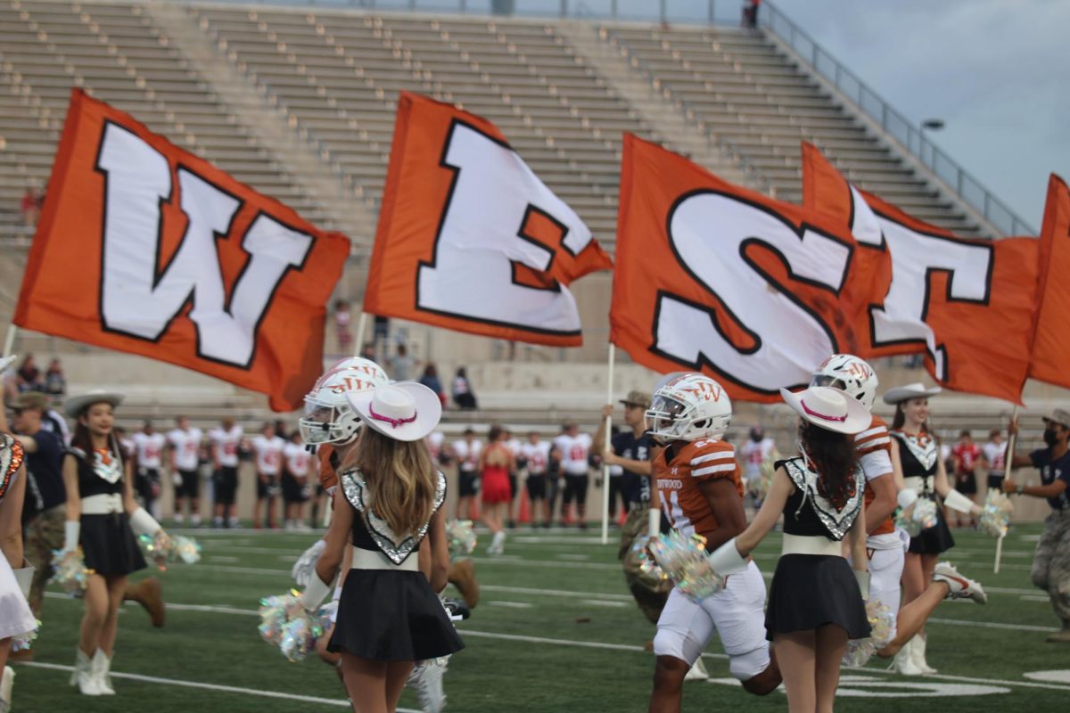 Running, JROTC commemorates a touchdown during the Homecoming football game on Friday, Oct. 13. The Warriors emerged victorious against the  Mavericks with a final score of 17-14.
