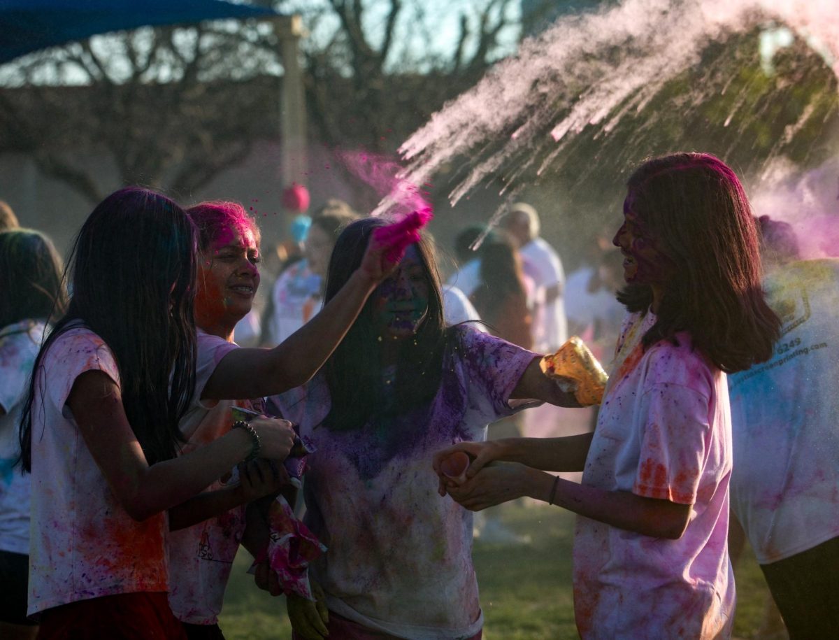 Celebrating with her friends, Aanya Ujjval '26 gets sprayed with color powder. All profits from the Holi festival through selling powder and shirts were donated to Casa Marianella.