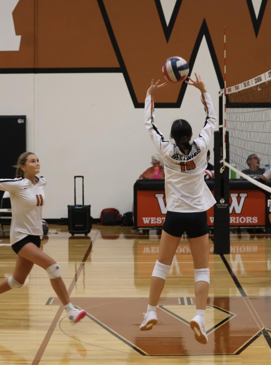 Showcasing practiced coordination, Sophie Chen '29 springs upwards to set the ball for her teammate, Liberty Hargave '29. Prepared, Hargave runs forward in the hopes of achieving a kill.