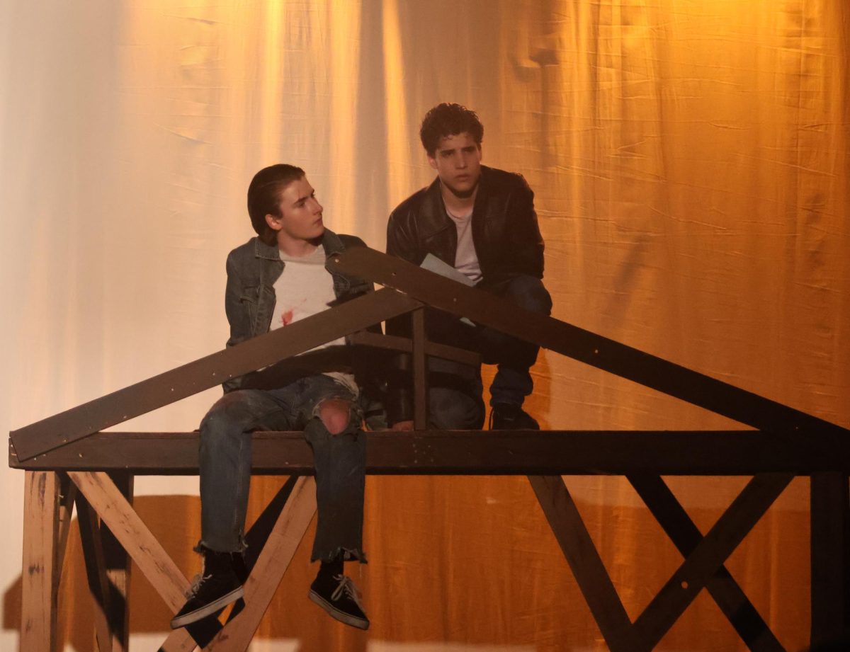 Sitting on top of the church set, Koen Keene '27 and Ivan Schere '27 create an iconic moment from "The Outsiders." The golden lighting was used to symbolize the poem called "Nothing Gold Can Stay" that Schere's character recites.