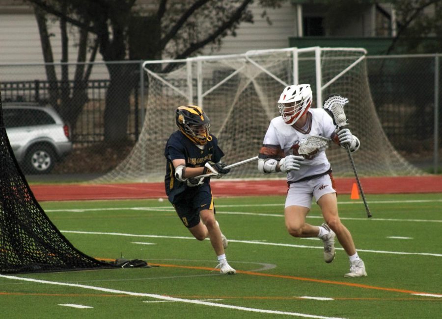 Behind the goad, Bodie Bradley '23 goes around the Highland Park defense to attempt a goal.