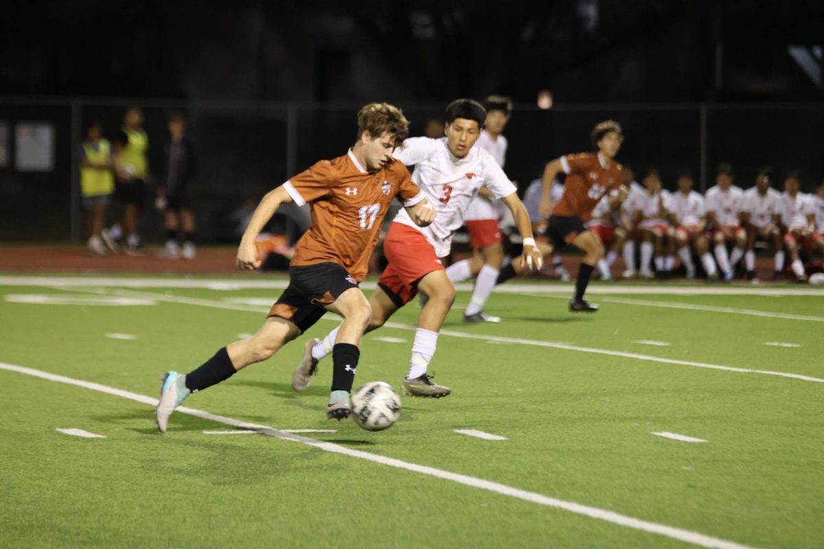 Braden Wilson ‘24 expertly dribbles the ball around Mustang defenders to bring the ball closer to the goal. Wilson was a key player in the game, especially in the first half. 