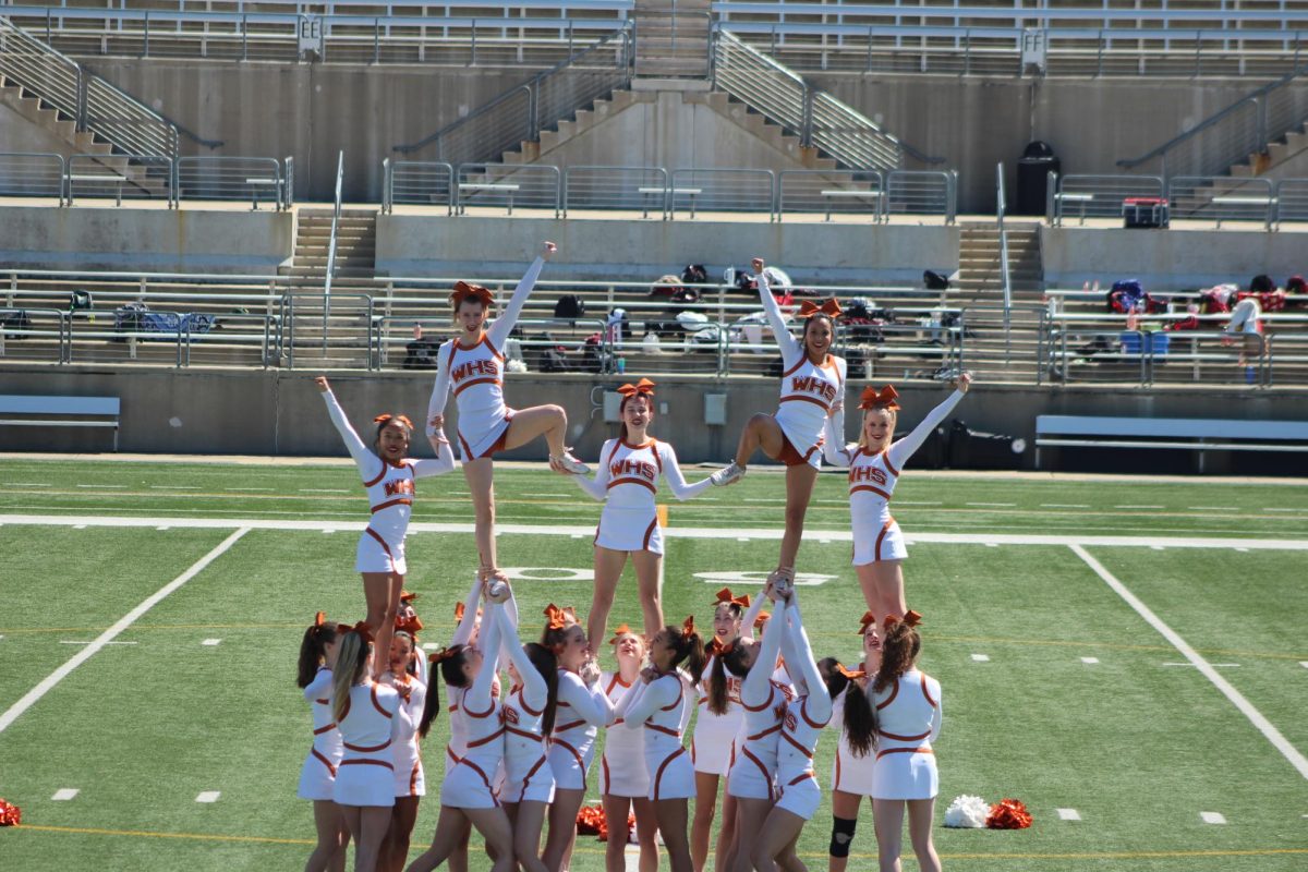 Smiling wide, the flyers hit their final pose in the pyramid. The team had just hit the pyramid successfully. 
