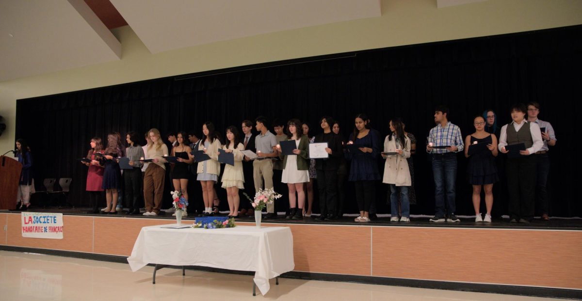 Standing on stage, National French Honors Society (SHF) inductees hold their candles and listen to a speech by president of SHF Nitya Khurana '24. Proudly inducting new members, Khurana highlighted the value of continuing on learning the French language.