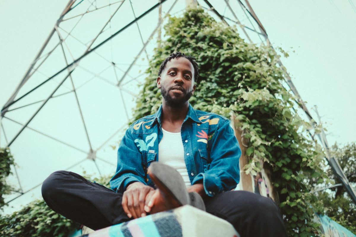 Sitting in front of a metal structure, Daniel Fears poses outside. Fears believes that sharing his art is synonymous with sharing his soul. "They have something to give back to me, whether it be music, or appreciation, or good stories," Fears said.