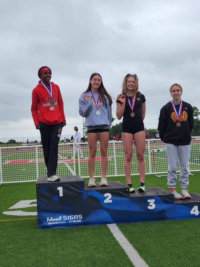 Violet Hewett '25 and Kenzie McElroy '24 pose after getting second and third place for long jump at the area meet.