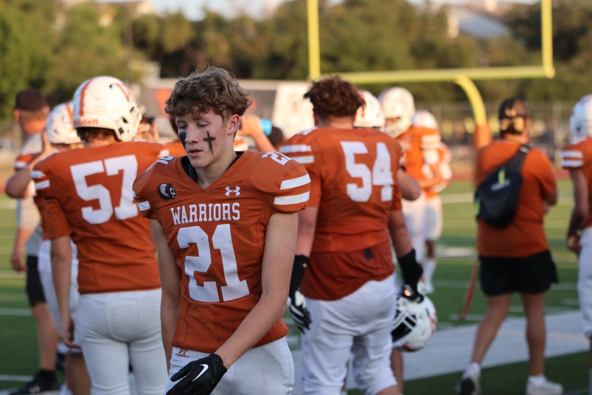 Cole Goehring '26 walks along the sidelines during a transitional period on his way to the bench. The Warrior defense spent most of the time on the field as the offense struggled to find points.  