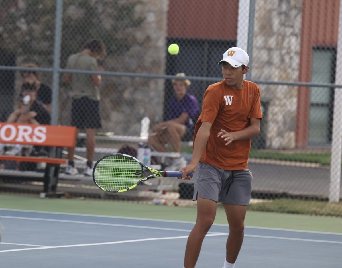 Daniel Zhang '26 reaches for the ball during his doubles match with Arjun Rajan ‘25. 