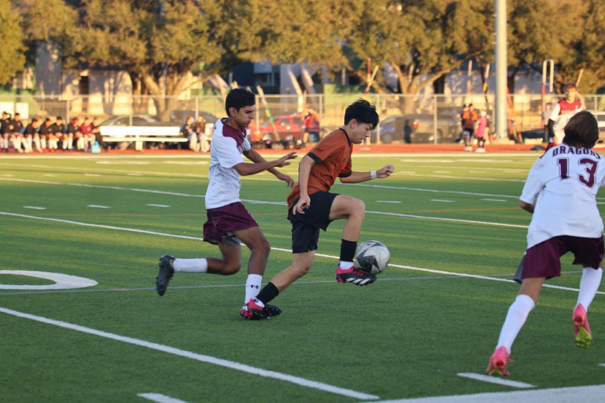 Running with the ball up the field, Aiden Shen '26 shields it from a defender. A key player in this game, Shen scored both goals for the team. 
