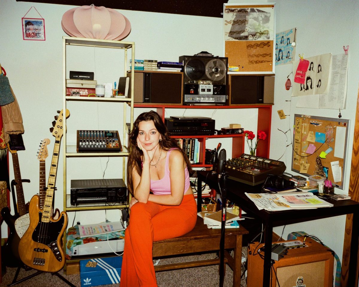 Posing at a desk, Lindsey Mackin of retro-grunge band Annabelle Chairlegs sits in her studio. Mackin recently recorded her third album, which is currently unreleased. "I remember being a kid and thinking like 'oh if I wanna be a singer I have to be like a pop star, like that’s how women do music,'" Mackin said.