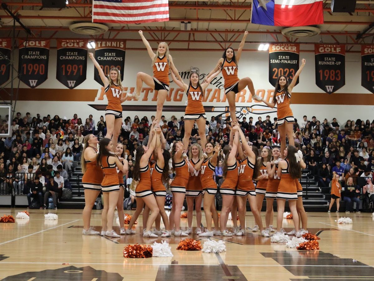 Forming a pyramid formation, the Cheer team conclude their performance. Some members held the "sko wood" symbol, amplifying school spirit. 
