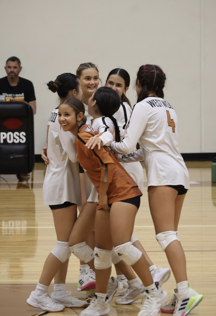 Beaming, Kimmie Menendez '28 searches for her family in the stands while hugging her teammates. The girls were overjoyed after winning Set 2, rallying together to gather energy for the next one. 