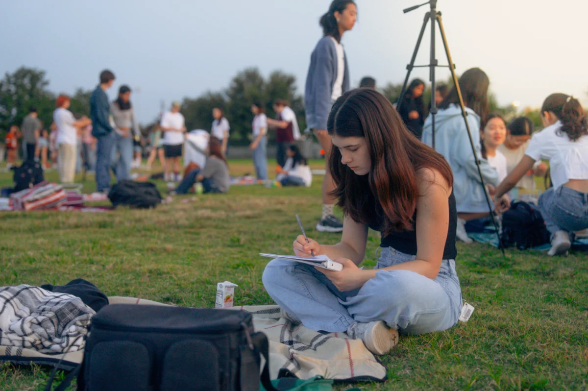 Sitting on a picnic blanket, Aubrey Tipps '26 writes a letter to her future self. Letter writing was one of the activities set up by Student Council, and these messages would be given back to the students at the end-of-year event, Senior Sunset. 
