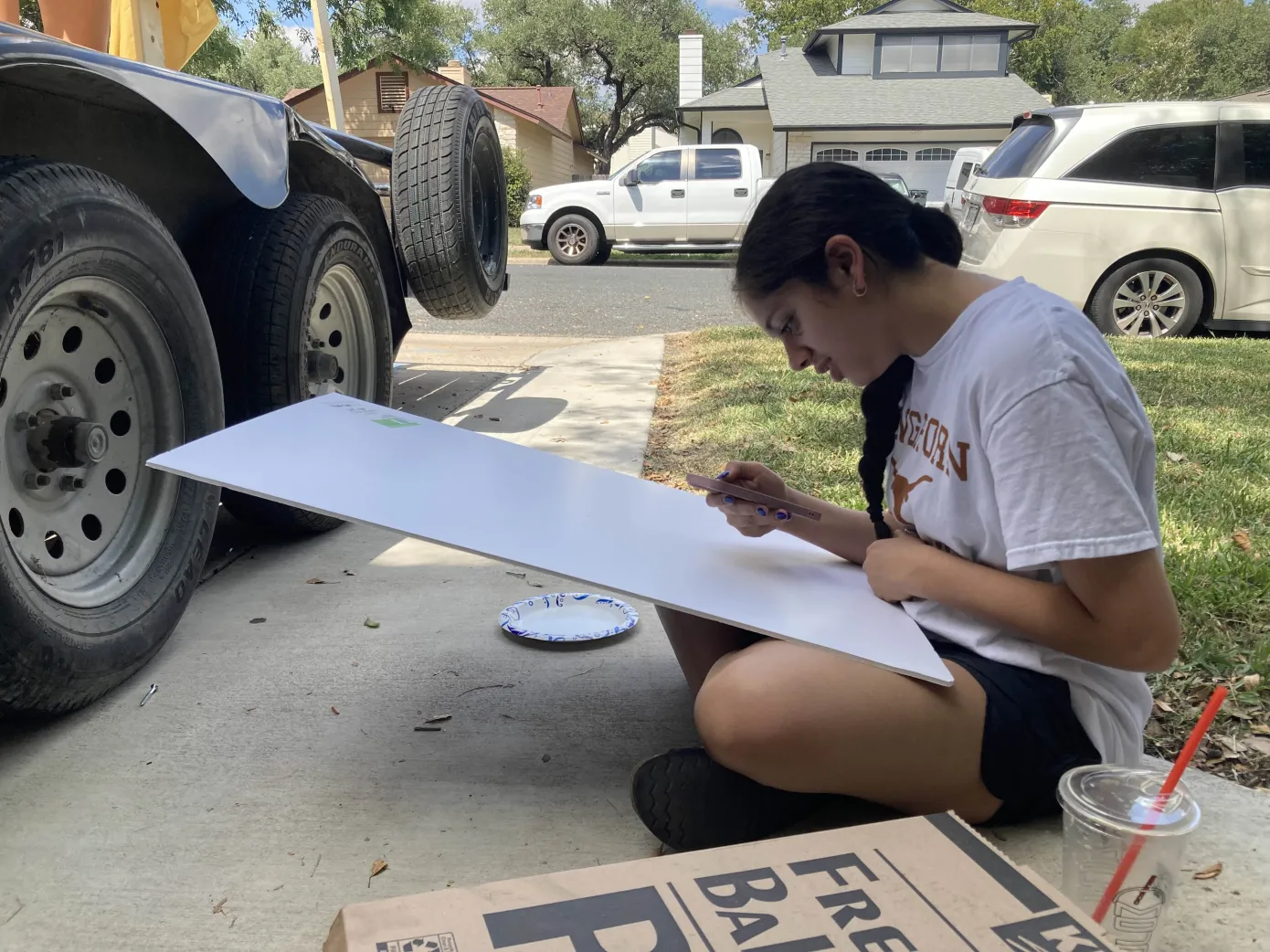 Painting the vision, Student Council (StuCo) Junior Class Secretary Sheerali Talati references the design for the float decoration board. The Class of 2027 decorated their float from noon to 4 p.m. on Saturday, Sept. 13.